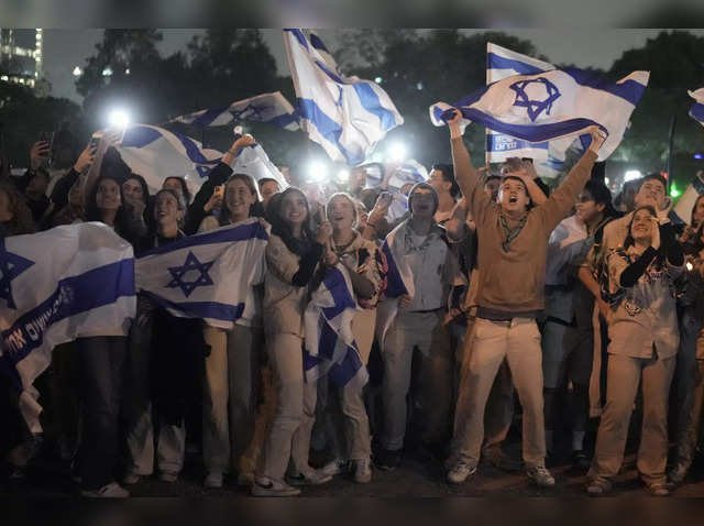 A group of Israelis celebrate as a helicopter carrying hostages released from the Gaza Strip 